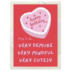 May include: A red card with a pink heart-shaped cake that says "happy birthday" on it. The card says "May it be: VERY DEMURE VERY MINDFUL VERY CUTESY"