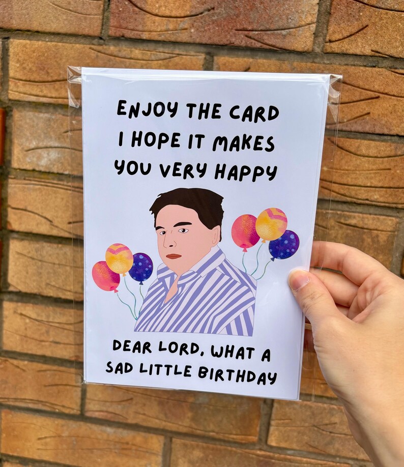 May include: A birthday card featuring a cartoon illustration of a person and balloons. The card's text reads: "ENJOY THE CARD I HOPE IT MAKES YOU VERY HAPPY DEAR LORD, WHAT A SAD LITTLE BIRTHDAY."