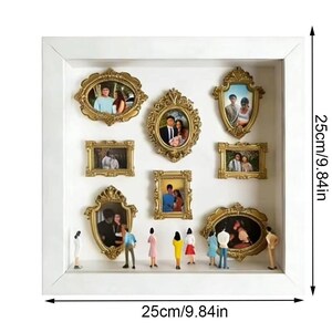 May include: A white shadow box with nine gold-framed pictures, each containing a photograph. The box is 9.84 inches square. Miniature figures are positioned at the bottom of the box, adding a sense of scale and depth to the display.