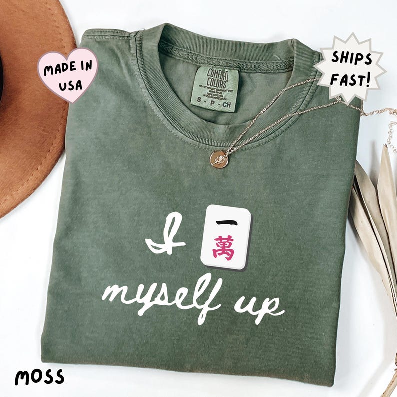 comfort colors moss green mahjong shirt with funny “I crack myself up” quote and Crak tile, earthy toned gift for mahjong players, ideal for relaxed cozy lifestyle outfits