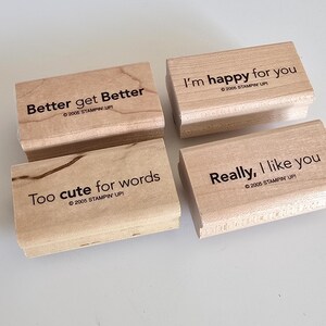 May include: Four wooden stamps with black text: "Better get Better", "I'm happy for you", "Too cute for words", and "Really, I like you". Each stamp has the copyright "©2005 STAMPIN' UP!". The stamps are light brown.
