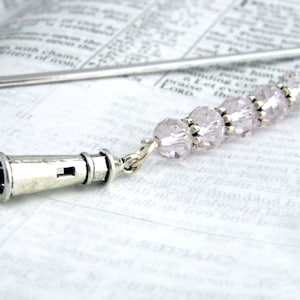 May include: Silver bookmark with a lighthouse charm and a chain of pink crystal beads.