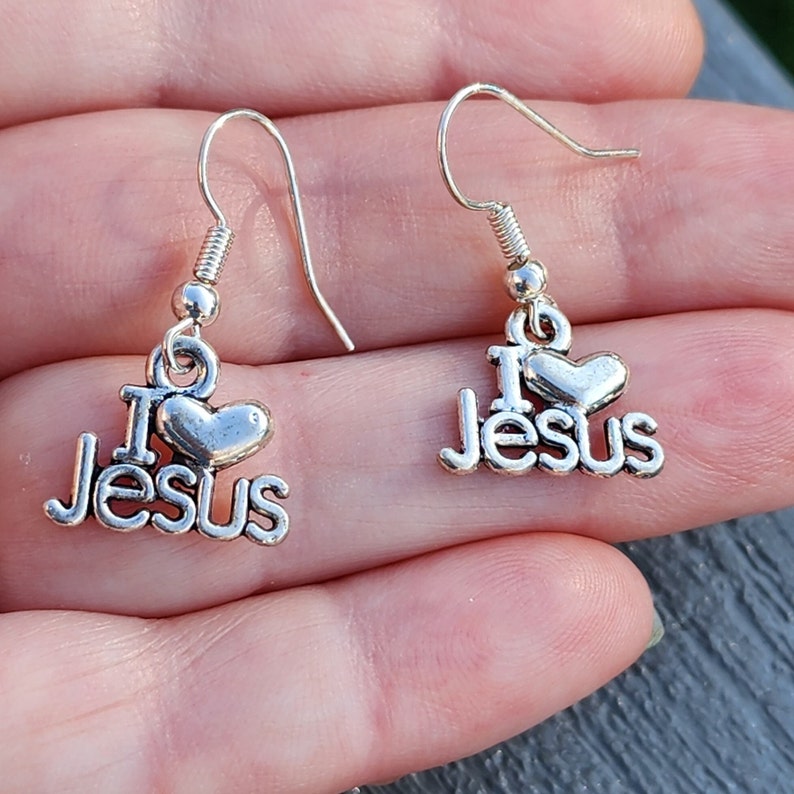 Pu&ograve; includere: Orecchini pendenti in argento con un cuore e le parole "I Love Jesus".