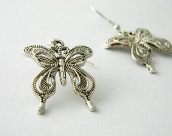 May include: Silver-toned butterfly earrings. The earrings feature a detailed filigree design, with the butterfly's wings and body intricately crafted. One earring is a stud, and the other is a dangle earring with a hook. The earrings are set against a white background.