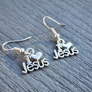 Pu&ograve; includere: Orecchini d'argento con un cuore e le parole "I Love Jesus".