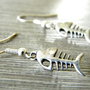 May include: Silver fish bone earrings with a hook closure.