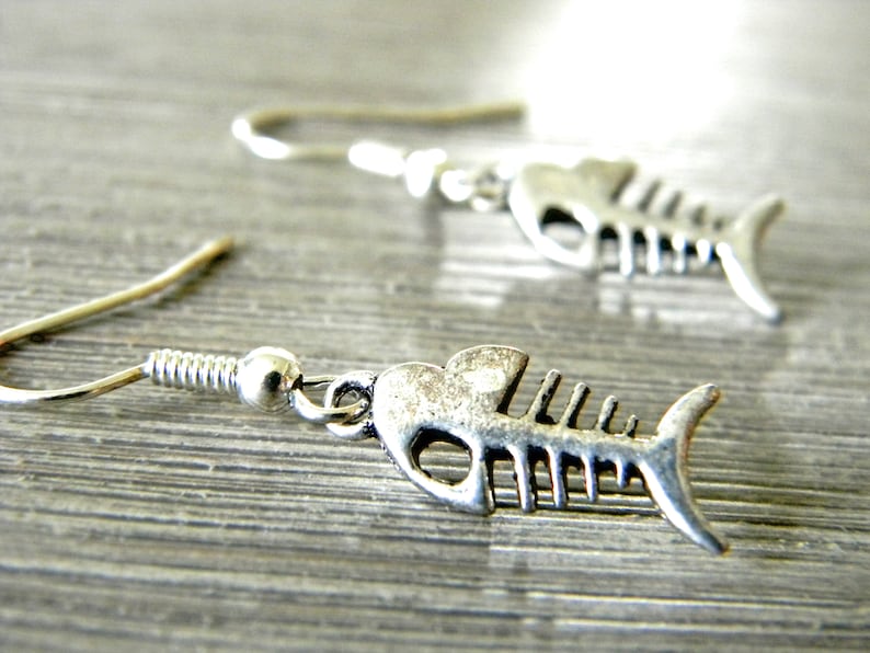May include: Silver fish bone earrings with a hook closure.