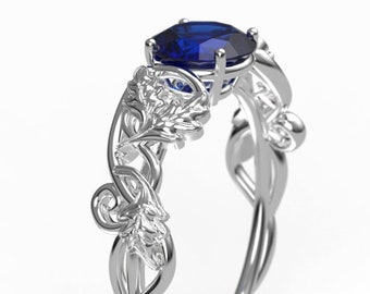 Anillo de compromiso de oro blanco con hoja de roble y anillo celta con zafiro sintético.