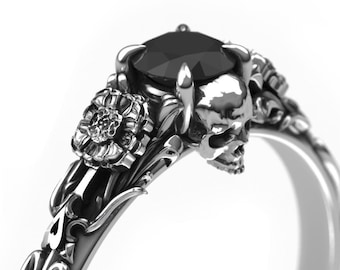May include: A silver ring with a black gemstone, a skull, and floral details.