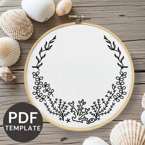 May include: A white fabric embroidery hoop with a black botanical design. The design includes leaves, branches, and coral-like elements. The text "PDF TEMPLATE" is in a circle at the bottom. Seashells are scattered around the hoop.