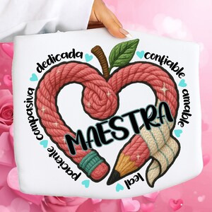 Könnte beinhalten: Weiße Tragetasche mit einem herzförmigen Design aus rotem Seil, einem Bleistift und dem Wort "MAESTRA". Das Design enthält die Wörter "mitfühlend", "engagiert", "zuverlässig", "freundlich", "loyal" und "geduldig".