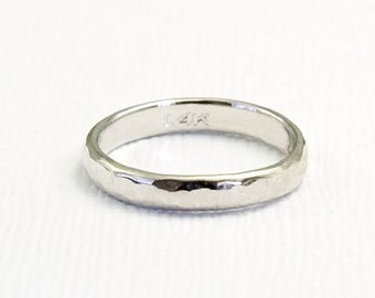 May include: A simple, silver band ring with a hammered texture. The ring is marked "14K" on the inside.
