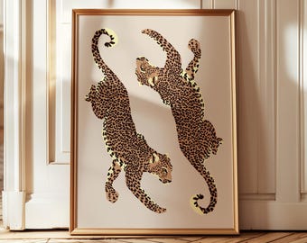 Può includere: Stampa artistica incorniciata con due leopardi stilizzati con macchie marroni su sfondo beige. I leopardi sono raffigurati in pose dinamiche, su uno sfondo neutro e incorniciati da un bordo dorato. Adatta per l'arredamento della casa.