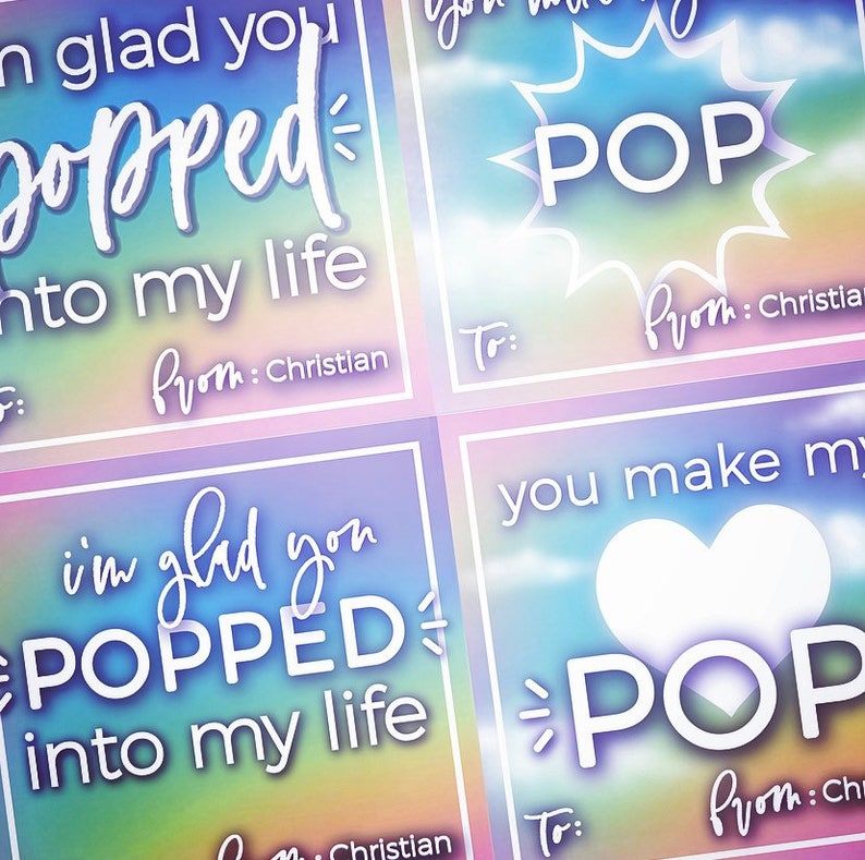 May include: Four colorful square cards with a rainbow background and white text. The text on the cards reads "I'm glad you popped into my life" and "You make my heart pop". The cards are decorated with a starburst and a heart.