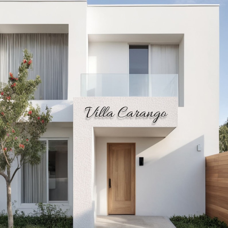 May include: A white modern house with a wooden door and a glass balcony. The house has a sign that reads "Villa Carango".