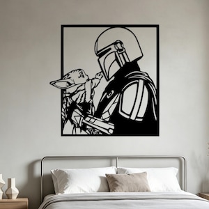 Könnte beinhalten: Ein schwarzes Wandkunstobjekt aus Metall mit einem quadratischen Rahmen, das die Silhouette einer behelmten Figur und eines kleinen Wesens mit großen Ohren zeigt, das nach der Figur greift. Das Design ist flach, einfarbig und minimalistisch.