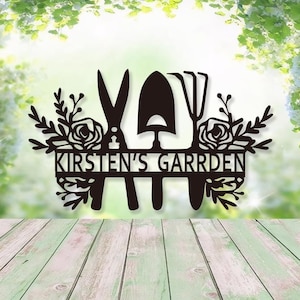 Può includere: Un cartello da giardino in metallo nero con la scritta "KIRSTEN'S GARRDEN". Il cartello presenta attrezzi da giardino, tra cui forbici, una cazzuola e un rastrello, circondati da elementi floreali. Il cartello è progettato per uso esterno.