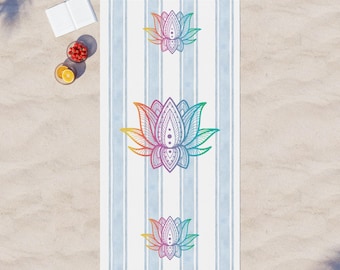 May include: A white beach towel with blue stripes and a rainbow colored lotus flower design. The towel has fringe on the ends.
