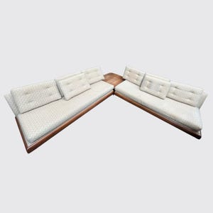 May include: A white and brown sectional sofa with a patterned fabric and a small wooden table in the middle.