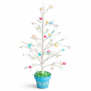 May include: A decorative Easter tree with a white trunk and branches, adorned with pastel-colored Easter eggs and white flowers. The tree is planted in a light blue pot with floral designs and green paper grass.