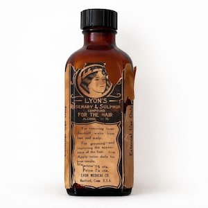 May include: An antique brown glass bottle with a black cap, featuring a peeling label with the text "LYON'S ROSEMARY & SULPHUR COMPOUND FOR THE HAIR." The label includes instructions and the name of the manufacturer, Lyon Medical Co.