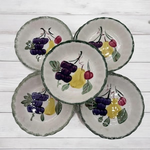 May include: Set of five white ceramic bowls with green trim. Each bowl features a hand-painted design of pears, grapes, and cherries in shades of yellow, purple, red, and green.
