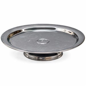 Op de afbeelding: Een ronde taartstandaard van zilverkleurig metaal met een gepolijst, reflecterend oppervlak. De standaard heeft een brede, platte schaal met een licht opstaande rand en een centrale cirkelvormige inkeping, rustend op een stevige voet.