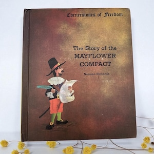 May include: A vintage book titled "Cornerstones of Freedom: The Story of the Mayflower Compact" with an illustration of a pilgrim holding a scroll. The cover is brown with text in white and a colorful illustration.