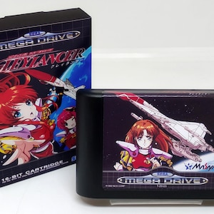 May include: A black Sega Mega Drive game cartridge featuring a colourful image of a female character in a red and white suit, a spaceship, and the text "Gleylancer" on the front. The game cartridge is next to a black box with the same image and the text "Sega Mega Drive Gleylancer".