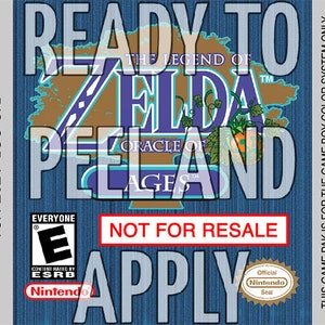 Może przedstawiać: Gra Game Boy Color w niebiesko-białej obudowie do gry The Legend of Zelda: Oracle of Ages. Etykieta zawiera napis "Ready to Peel and Apply" oraz "Not for Resale".