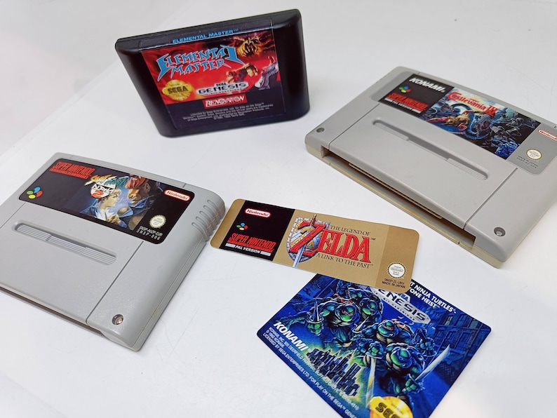 Może przedstawiać: Kolekcja gier wideo na konsole Super Nintendo i Sega Genesis. W zestawie znajdują się gry: "Street Fighter II Turbo: Hyper Fighting", "The Legend of Zelda: A Link to the Past", "Teenage Mutant Ninja Turtles: Turtles in Time" oraz "Elemental Master:  Elemental Matter".
