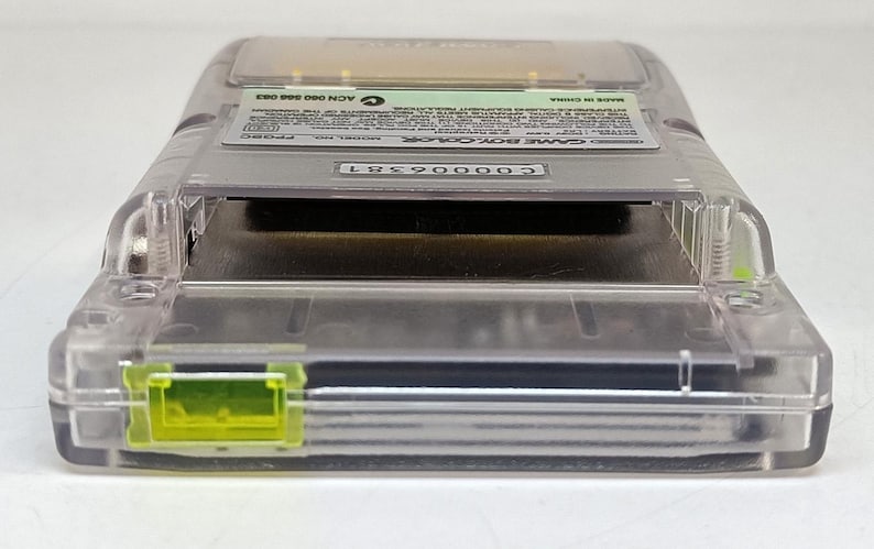 Puede incluir: Un cartucho transparente de Game Boy Color con un mecanismo de bloqueo amarillo. El cartucho tiene una etiqueta con texto y un n&uacute;mero de serie. La Game Boy Color es un dispositivo de juego port&aacute;til.