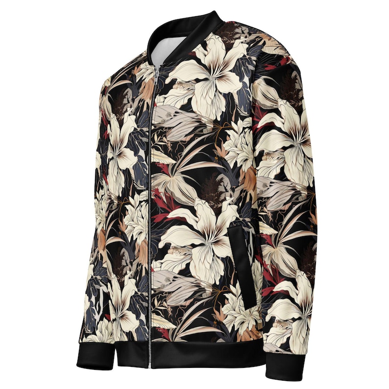 May include: A black bomber jacket with a floral print featuring white, red, and brown flowers. The jacket has a zipper closure and ribbed cuffs and hem.