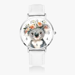 Puede incluir: Un reloj de pulsera blanco con caja plateada y correa de cuero blanca. La esfera del reloj presenta una ilustración de acuarela de un koala con una corona floral. El reloj tiene números y agujas negros.
