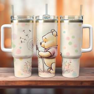 Peut inclure: Un gobelet en acier inoxydable blanc avec un motif Winnie l'ourson. Le gobelet présente une image de dessin animé de Winnie l'ourson soufflant sur un pissenlit. L'arrière-plan est beige clair avec des points de couleur pastel.