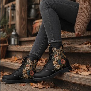 Könnte beinhalten: Schwarze Combat-Stiefel mit einem Hirsch- und Blumenmuster. Diese Schnürstiefel haben eine robuste Sohle. Das Design zeigt einen Hirsch inmitten bunter Blumen und bietet einen von der Natur inspirierten Look.