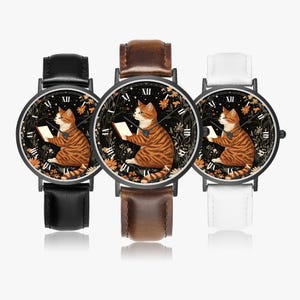 May include: Three wristwatches with black, brown, and white leather straps. Each watch face features a tabby cat reading a book, surrounded by floral and leaf designs. The watch hands show the time.