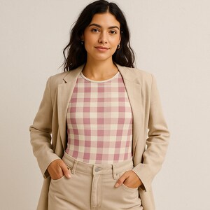 May include: A woman in a light beige blazer, light beige trousers, and a pink and white gingham print top. The top has a round neckline and is form-fitting. The outfit is a neutral colour palette.