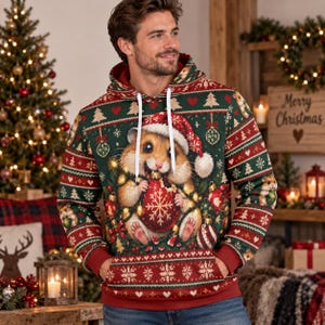 May include: A dark green hoodie featuring a festive holiday pattern with red and white accents. The centre graphic depicts a hamster wearing a Santa hat and holding a red ornament. The design includes repeating motifs of snowflakes, hearts, and Christmas trees.