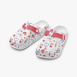 Pode incluir: Tamancos brancos com um padrão médico com corações, estetoscópios, seringas e pensos. Os tamancos têm uma tira vermelha e são projetados para conforto. Estes sapatos são ideais para profissionais de saúde.