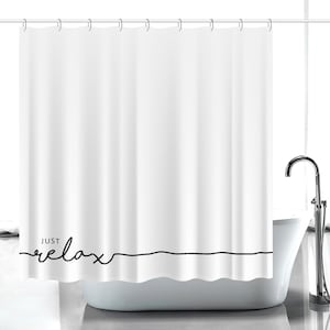 Puede incluir: Cortina de ducha blanca con las palabras "just relax" en escritura negra. La cortina cuelga de una barra plateada y está parcialmente corrida, revelando una bañera blanca y un grifo plateado. El tema general es la decoración del baño.