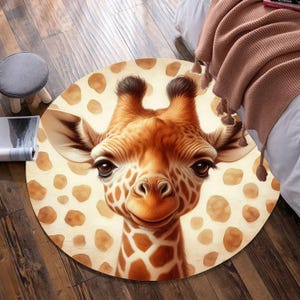 May include: A round, cream-coloured rug with a brown giraffe pattern. The giraffe has a friendly expression and is surrounded by brown spots.