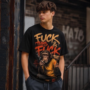 Könnte beinhalten: Ein schwarzes kurzärmeliges T-Shirt mit einer Grafik eines Schimpansen in einem gelben Shirt, der eine Zigarette raucht und den Mittelfinger zeigt. Der Text lautet "FUCK THIS & FUCK THAT!" in Orange und Gelb, mit "SHIT FUCK EVERYTHING" darunter.