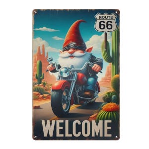 以下が含まれることがあります： ルート66を赤いバイクに乗るノームを描いたヴィンテージメタルサイン。ノームは赤い帽子と革のジャケットを着ています。サインは砂漠の風景を背景に、下部に「WELCOME」の文字があります。