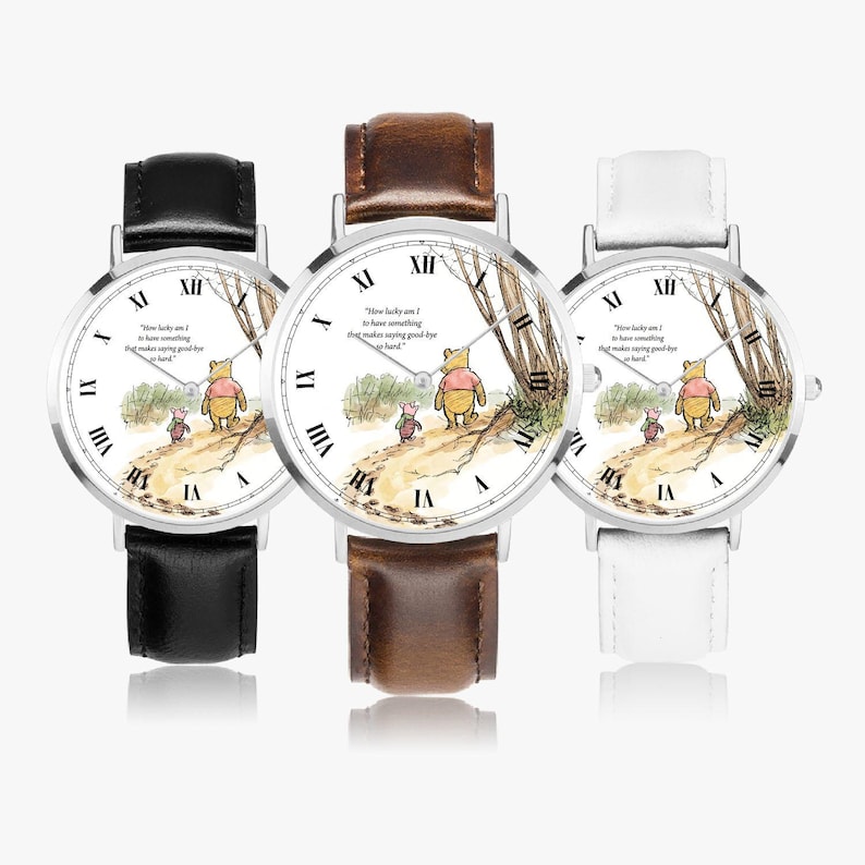 Pode incluir: Tr&ecirc;s rel&oacute;gios de pulso com caixas prateadas e pulseiras de couro em preto, castanho e branco. Os mostradores apresentam uma ilustra&ccedil;&atilde;o de Winnie the Pooh com a cita&ccedil;&atilde;o "How lucky am I to have something that makes saying goodbye so hard."