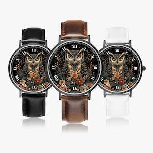 May include: Three wristwatches with black, brown, and white leather straps. Each watch face features a detailed owl illustration with floral accents and Roman numeral hour markers. The watch cases are black.