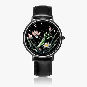 May include: Black wristwatch with a round face featuring a green praying mantis, pink lotus flowers, and white flowers against a black background. The watch has a black leather band and a black case with Roman numeral hour markers.