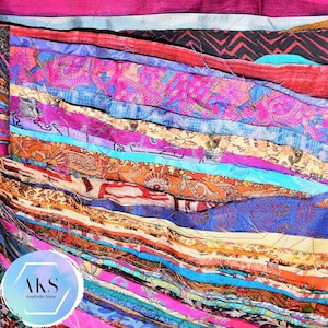 May include: A close-up of a stack of colourful fabric scraps, featuring a variety of patterns and textures. The fabric is arranged in a layered, cascading effect, creating a visually appealing and textured display. The fabric scraps are perfect for crafting, quilting, or other creative projects.
