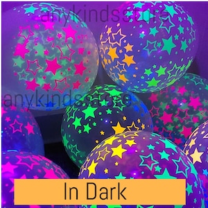 Può includere: Un gruppo di palloncini luminosi al buio con un motivo a stella. I palloncini sono trasparenti e hanno una varietà di colori, tra cui rosa, verde, giallo e blu. I palloncini sono illuminati in una stanza buia, mostrando l'effetto luminoso al buio. Il testo "In Dark" è visibile nella parte inferiore dell'immagine.