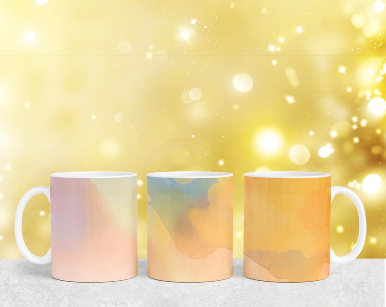 Puede incluir: Tres tazas de cer&aacute;mica con dise&ntilde;os abstractos de acuarela. Las tazas son en tonos de rosa, amarillo y naranja.